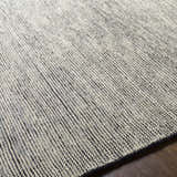 Close up of the hand knotted Molena Area Rug showing a textured denim and light olive wool design. Fold