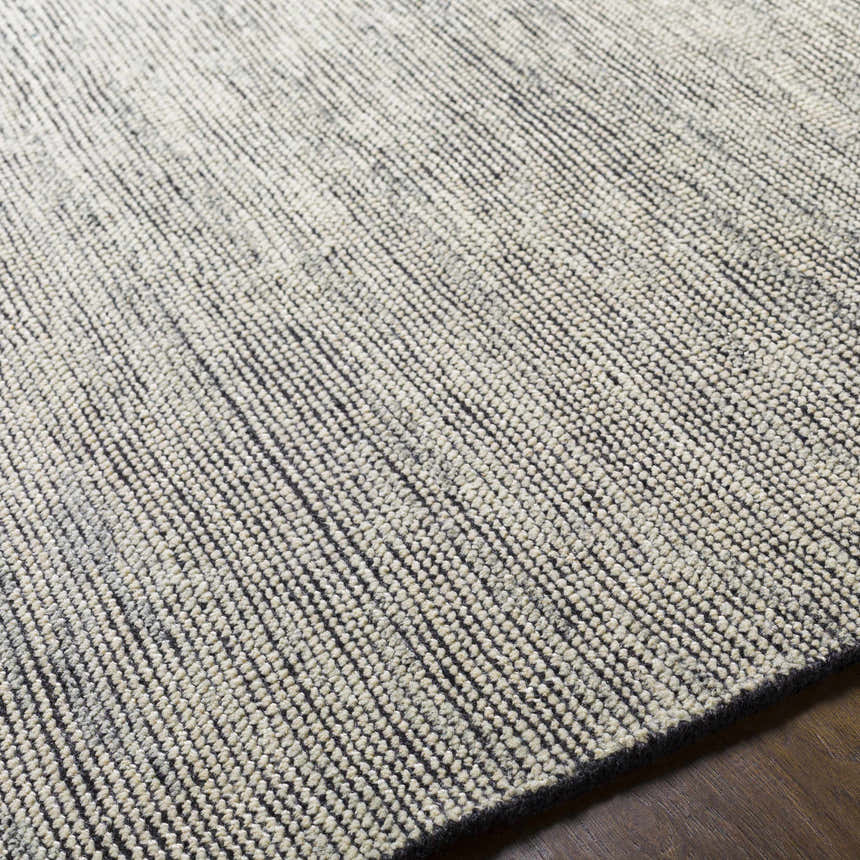 Close up of the hand knotted Molena Area Rug showing a textured denim and light olive wool design. Fold