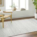 Light gray Morey Area Rug in a bright living room with wood floors, a chair, and a large window. Roomscene-Rectangle