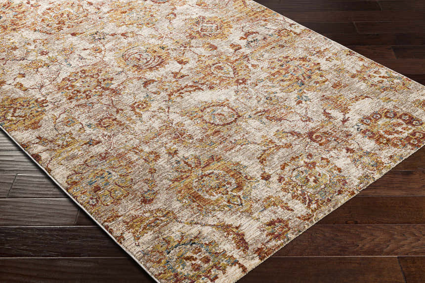 Close-up of the Morinville Area Rug showing its traditional floral pattern in brick red, charcoal, and light beige on dark wood floors. Corner