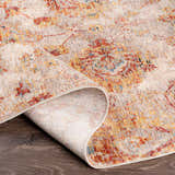 Close-up of the Morinville Area Rug showing brick red, charcoal, and mustard colors in a traditional oriental pattern. Fold