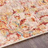 Close-up of the Morinville Area Rug. Features brick red, charcoal, light beige, and mustard colors in a traditional pattern. Texture