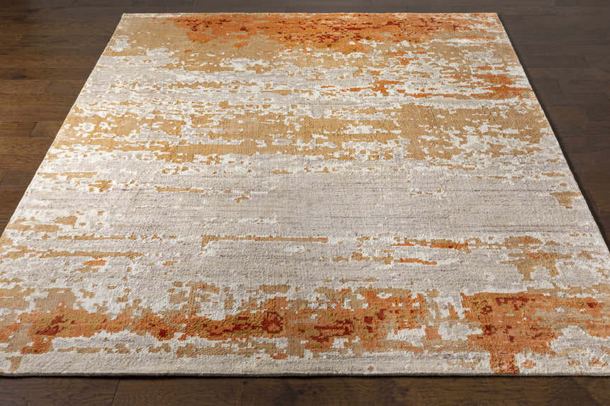 Close-up of Mossyrock Premium Rug showing brick red, camel, and cream abstract pattern and wool viscose texture. Front