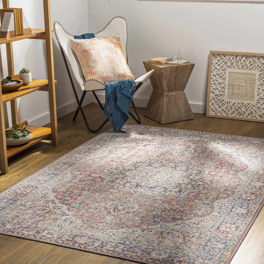 Living room scene with Cream Rust Maribojoc Medallion Washable Area Rug, white chair, wood accents, and neutral decor. Roomscene-Rectangle