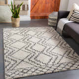 Living room scene with gray sofa and Mooroolbark Area Rug. Cream shag rug with gray geometric pattern. Roomscene-Rectangle