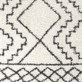 Close-up of the Mooroolbark Area Rug. Cream shag rug with a geometric diamond pattern in charcoal gray. Soft texture. Swatch