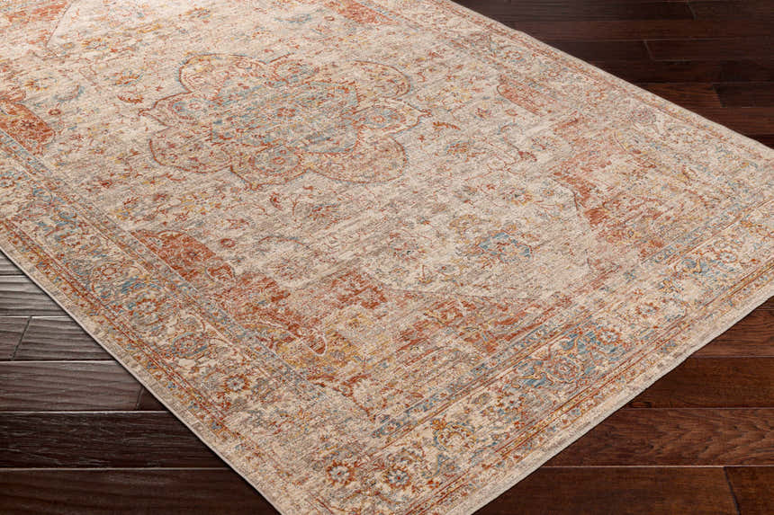 Close-up of the Marieville Luxe Performance Rug showing its cream, brick red, and blue oriental pattern on dark wood floors. Corner