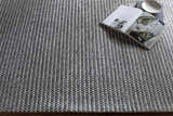 Close-up of the hand woven Mulgoa Area Rug. Medium gray rug with a contemporary design and textured wool and polyester feel. Styleshot