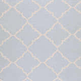 Close-up of the Nadeau Area Rug. Hand-woven wool rug in pale blue with a tan quatrefoil pattern. Swatch