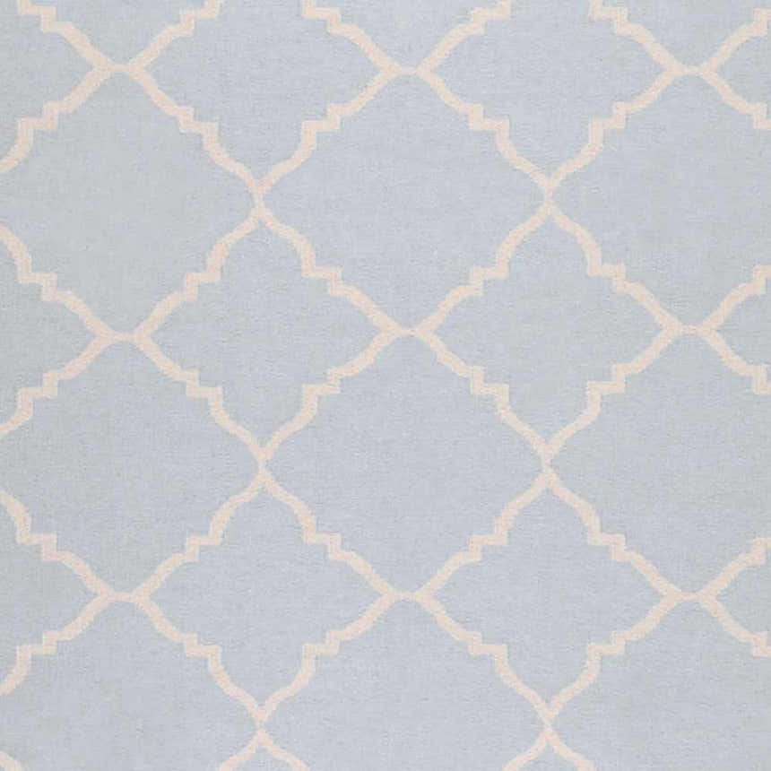 Close-up of the Nadeau Area Rug. Hand-woven wool rug in pale blue with a tan quatrefoil pattern. Swatch