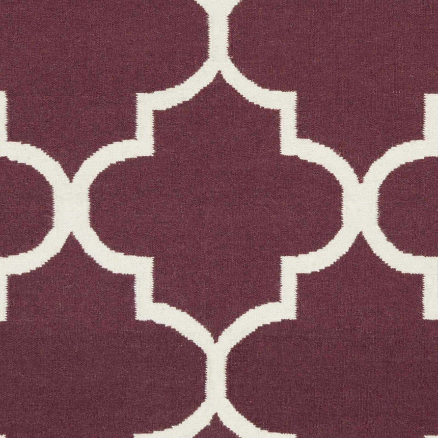 Close-up of the Nassau Area Rug showing a dark purple and ivory quatrefoil pattern. 100% wool texture. Swatch