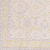 Close-up of the Navarino Area Rug showing its traditional pattern, light beige background, and accents of dusty pink, denim, and mustard. Swatch