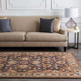 Living room scene with a beige sofa and the Cherryfield 1004 wool rug in beige, burnt orange, and slate blue tones. Roomscene-Rectangle