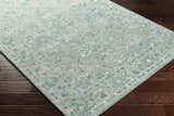 Close-up of the Neavitt Wool & Faux Silk Rug in aqua. Hand-tufted rug with traditional floral pattern and border. Corner