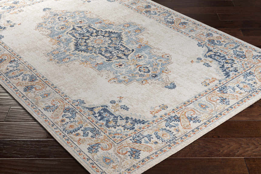 Close-up of the Neepawa Area Carpet showing its cream, aqua, dark blue, and orange traditional-style pattern. Corner