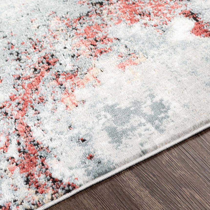 Close-up of the Kirkland Silver-Red Marble Rug. Abstract pattern in silver gray, beige, and burgundy on dark wood floor. Texture
