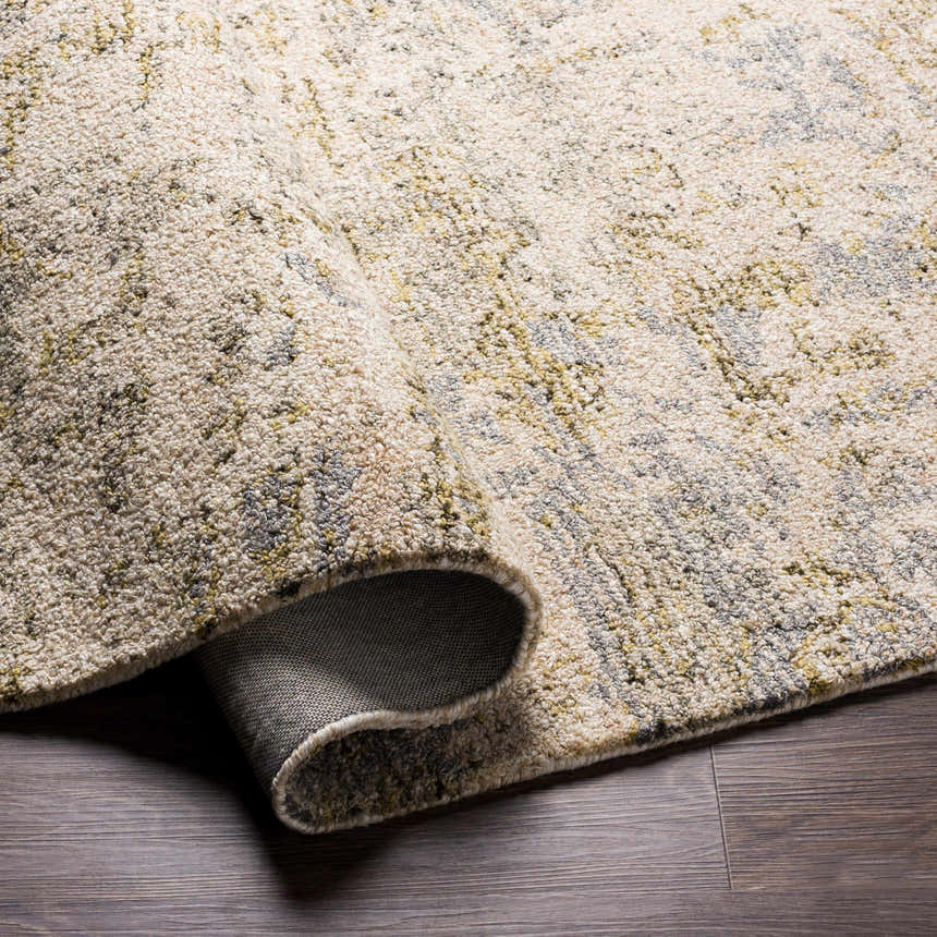 Close up of the hand tufted Namboongan Area Rug, showcasing its cream, charcoal, gray, and mustard colors. Fold
