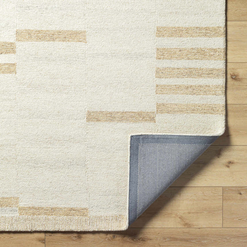 Close-up of the hand-tufted Nadav Beige Area Rug showing the ivory and tan geometric pattern and wool texture. Fold