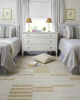 Light and airy kids bedroom with two beds featuring the Nadav Beige Area Rug. Roomscene-Rectangle