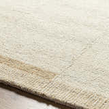 Close-up of the hand-tufted Nadav Beige Area Rug, showing its ivory and tan wool texture and subtle stripe design. Texture