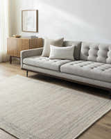 Living room scene with a gray sofa and the tan Nimue Area Rug on hardwood floors. Roomscene-Rectangle