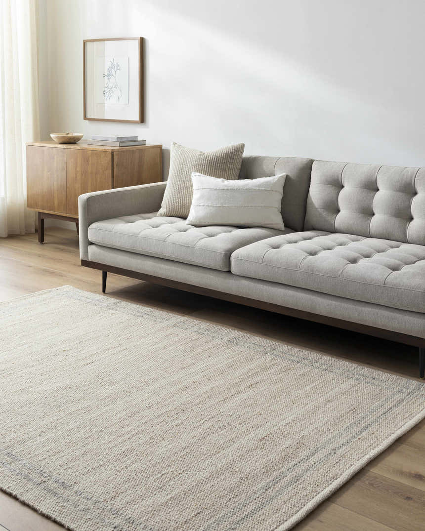 Living room scene with a gray sofa and the tan Nimue Area Rug on hardwood floors. Roomscene-Rectangle