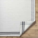 Close-up of the hand woven Nimue Cream & Blue Bordered Area Rug showing the wool texture and striped border. Fold