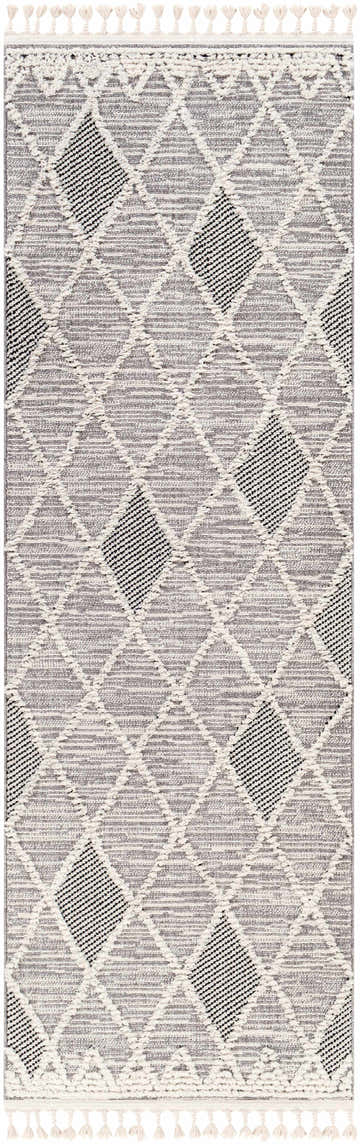 Close-up of the Norvelt High/Low Pile Rug. Gray rug with black diamond pattern and ivory tassels. Bohemian style. Design-Runner-2776