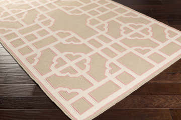 Close-up of Nova Area Rug. Hand-woven wool rug in beige with a geometric, light pink trellis pattern. Corner