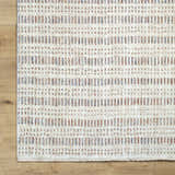 Close-up of the Nuhad Area Rug. Contemporary style rug with dark red, gray, navy, rust, and white geometric pattern. Corner