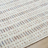Close-up of the Nuhad Area Rug with a contemporary geometric pattern in dark red, gray, navy, rust, and white. Texture