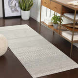 Entryway scene with Nunda Gray Rug in runner size. Gray, ivory, and silver tones complement the wood console table and dark floors. Roomscene-Runner
