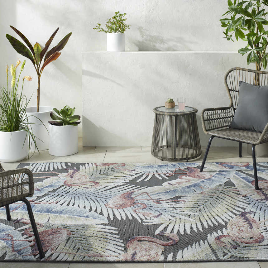 Coastal patio with Nayan Charcoal Area Rug. Features a flamingo and palm leaf pattern in blue, cream, and rust. Roomscene-Rectangle