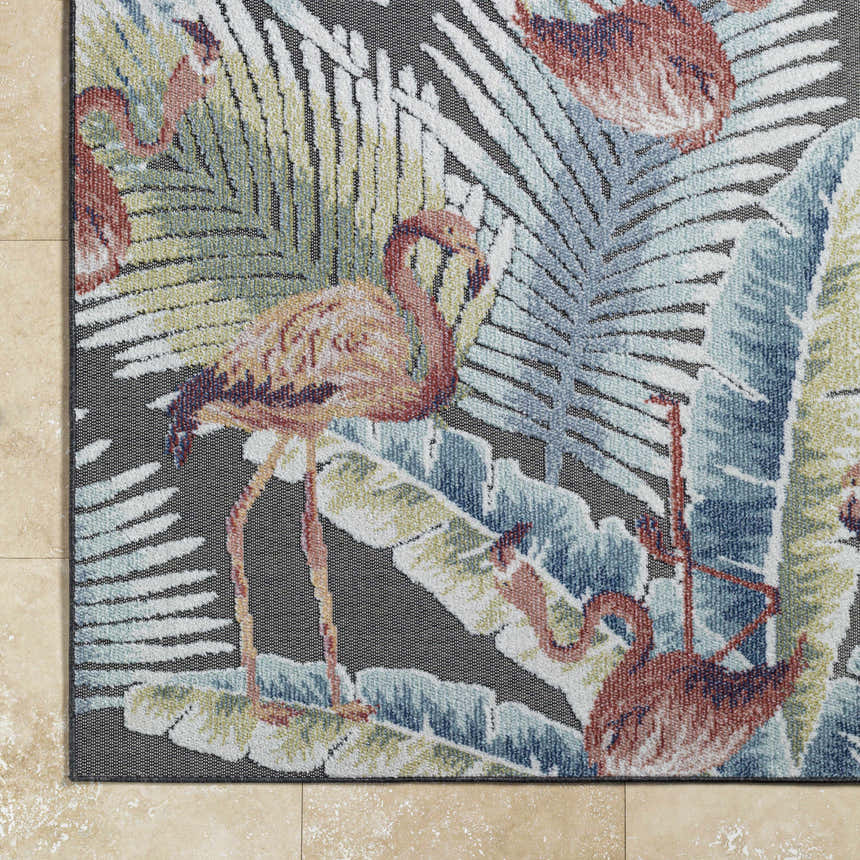Close-up of Nayan Charcoal Area Rug showing flamingo and tropical leaf design in blue, rust, and cream. Coastal style. Corner