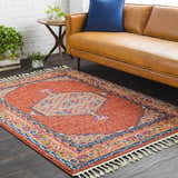 Living room scene with a camel leather sofa and the Oban Traditional Rug in coral and blue. Roomscene-Rectangle