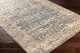 Close-up of Odala Luxe Performance Rug. Bohemian style rug in denim, beige, and mustard on dark wood floor. Corner