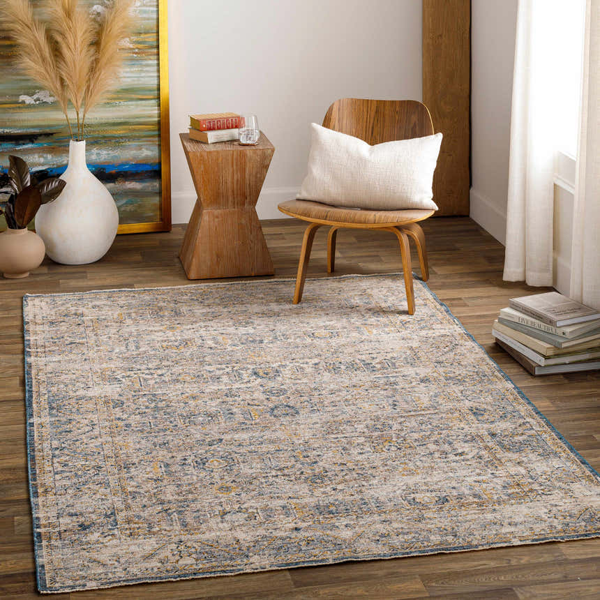 Living room scene with the Odala Luxe Performance Rug in light beige, blue, and gold. Wood chair and side table. Bohemian style. Roomscene-Rectangle