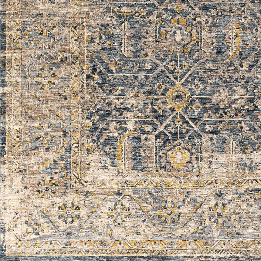 Close-up of the Odala Luxe Performance Rug. Features a traditional design in denim, beige, and mustard tones. Swatch