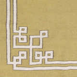Close-up of the hand woven Ogle Area Rug. Light beige wool rug with a contemporary olive and tan geometric border. Swatch