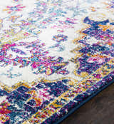 Close-up of the Okarche Area Rug, a machine-woven rug with a vintage pattern in burgundy, navy, teal, peach, and mustard. Pile