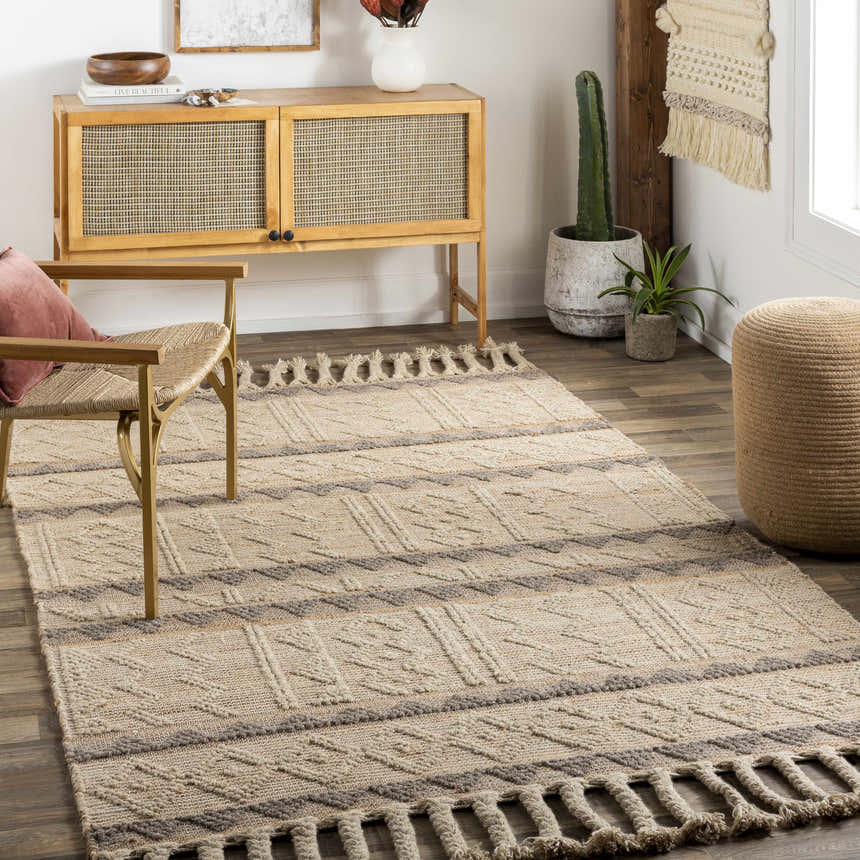 Living room scene with tan Okurcalar Area Carpet, woven chair, and wood cabinet. Bohemian style with jute and wool textures. Roomscene-Rectangle