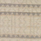 Close-up of Okurcalar Area Carpet. Hand-woven jute and wool rug with gray geometric patterns on a tan background. Swatch