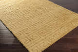 Close-up of the Omagh Area Rug in mustard. Hand-woven wool shag rug with a geometric Greek key pattern. Corner