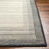 Close-up of the Omeo Wool Area Rug showing bone and dark gray horizontal stripes on a textured, hand-tufted surface. Front