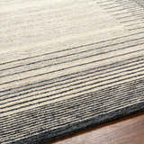 Close up of the Omeo Wool Area Rug showing bone and dark gray stripes and hand tufted texture. Texture