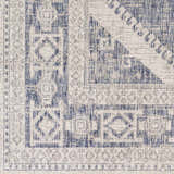 Close-up of the Umraniye Gray Area Rug featuring a blue geometric pattern on off-white polypropylene. Machine woven texture. Swatch