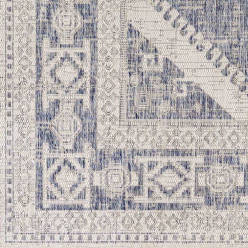 Close-up of the Umraniye Gray Area Rug featuring a blue geometric pattern on off-white polypropylene. Machine woven texture. Swatch