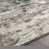 Close-up of the Opunake Luxe Thick Area Rug showing its abstract pattern in cream, gray, tan, brown, and black tones. Texture