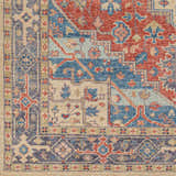 Close-up of the hand-knotted Oracabessa Premium Area Rug. Features a traditional Persian pattern in blue, red, and beige wool. Swatch