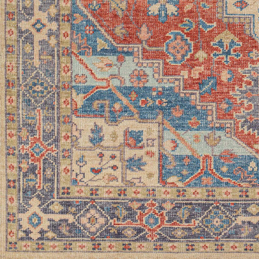 Close-up of the hand-knotted Oracabessa Premium Area Rug. Features a traditional Persian pattern in blue, red, and beige wool. Swatch